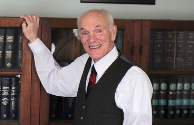 Attorney at Law George O. Wagner standing at bookshelf